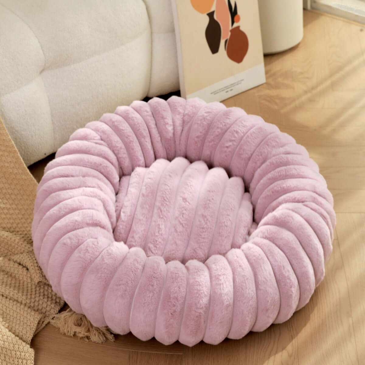 Plush pet bed for winter in soft pink color, featuring a cozy and comfortable round design for pets.