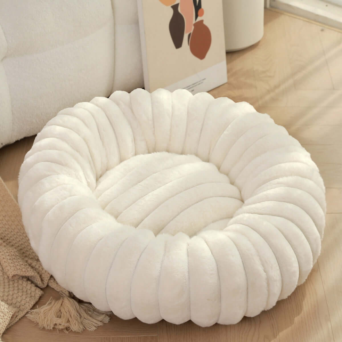 Plush pet bed for winter with soft, cozy white fabric and a round, padded design for ultimate pet comfort.